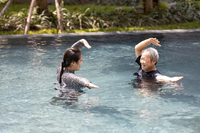 Two women doing aquatic therapy exercises in a pool