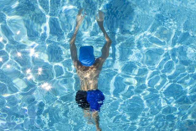 Child swimming breaststroke, seen from above
