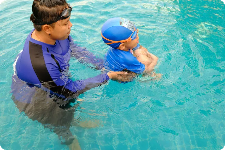 Coach teaching a toddler in the pool