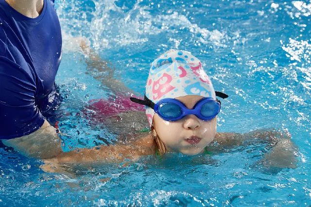 Coach with a girl in a one-on-one swimming lesson