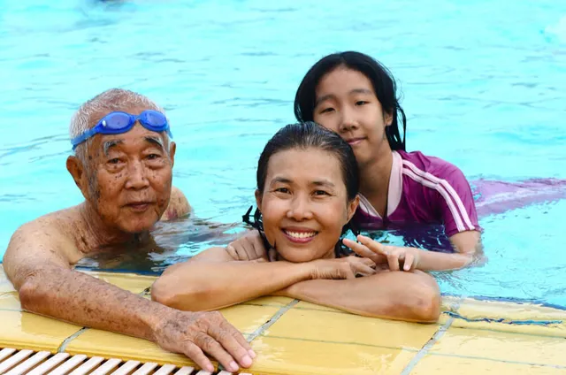 Grandfather, mother and daughter at the pool edge