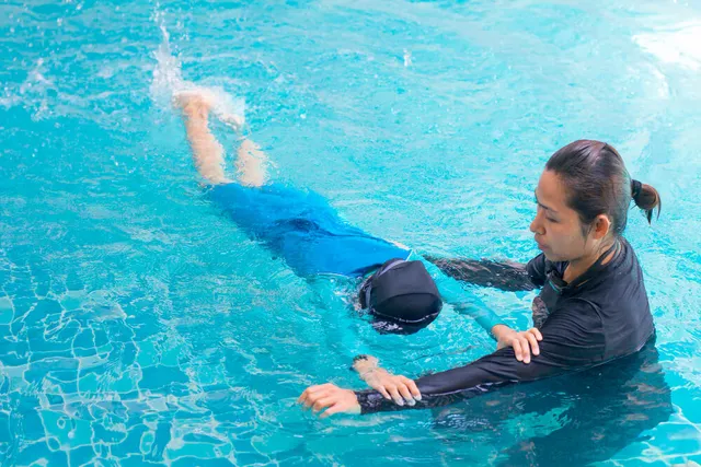 Female coach teaching a girl to swim