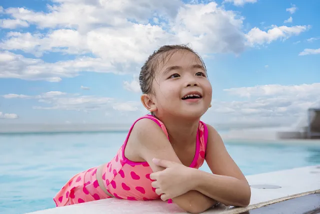 Girl resting her arms on the pool edge