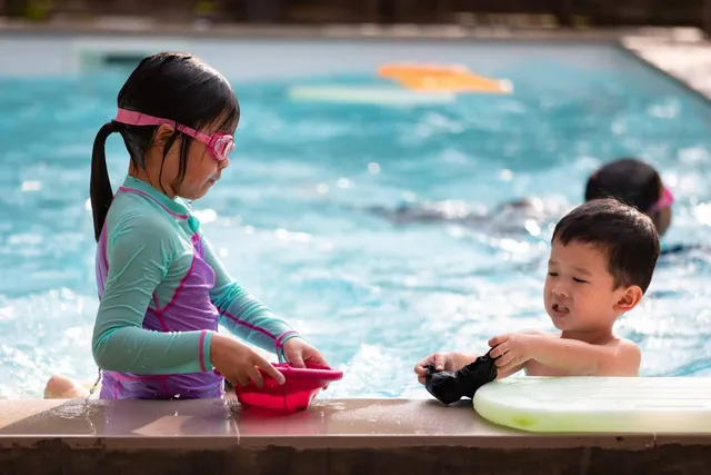 Two children playing at the pool edge
