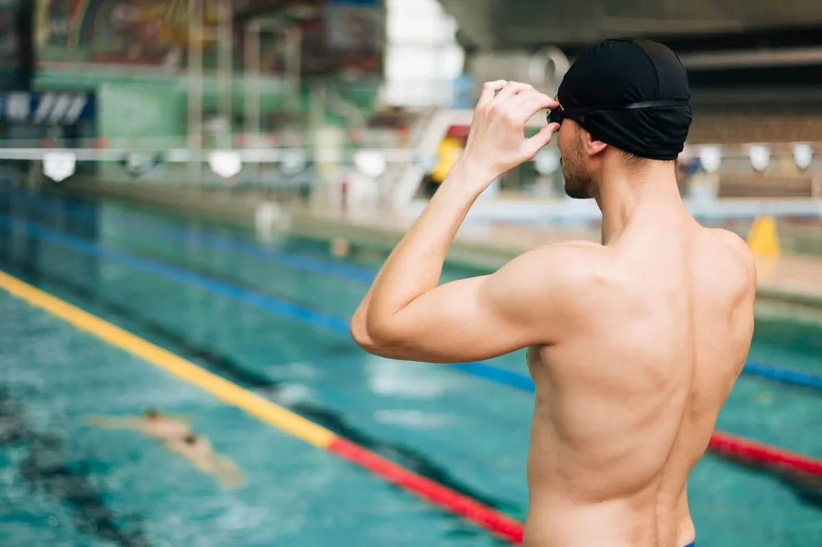 Male swimmer adjusting his cap before a workout