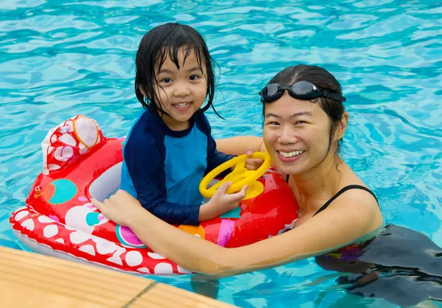 Mother and daughter with a swim tube in the pool