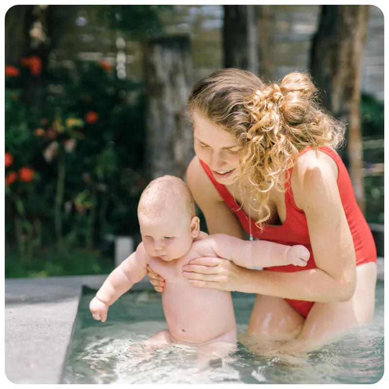 Mother holding her baby in a pool