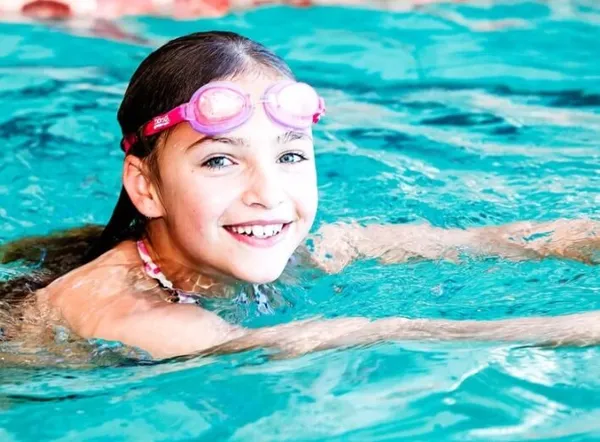 Smiling girl swimming in goggles