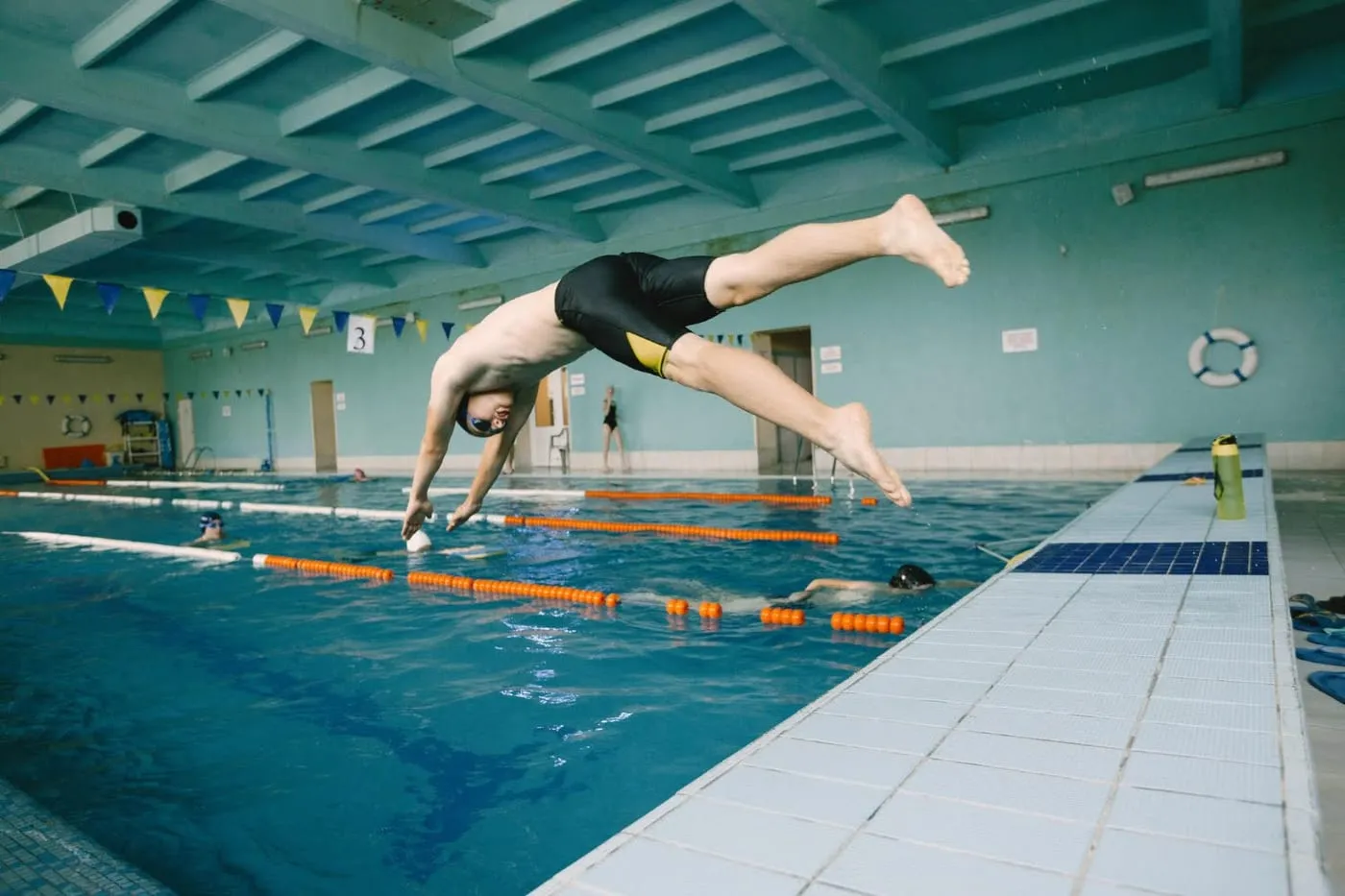 Swimmer diving off the pool edge