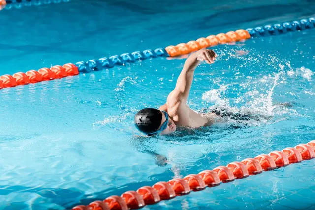 Swimmer doing freestyle between lane ropes