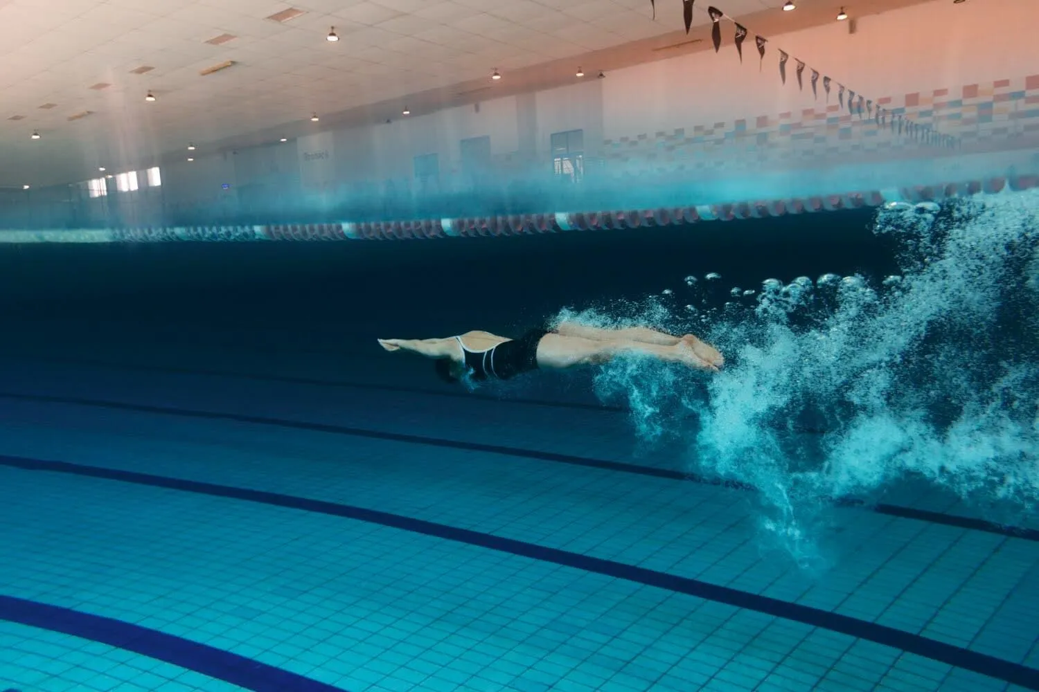 Swimmer kicking underwater in a pool lane