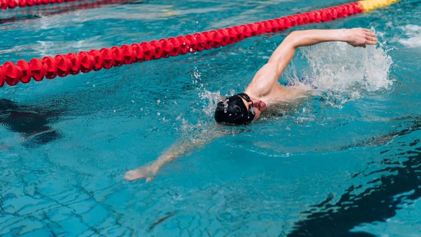Swimmer doing freestyle between lane ropes
