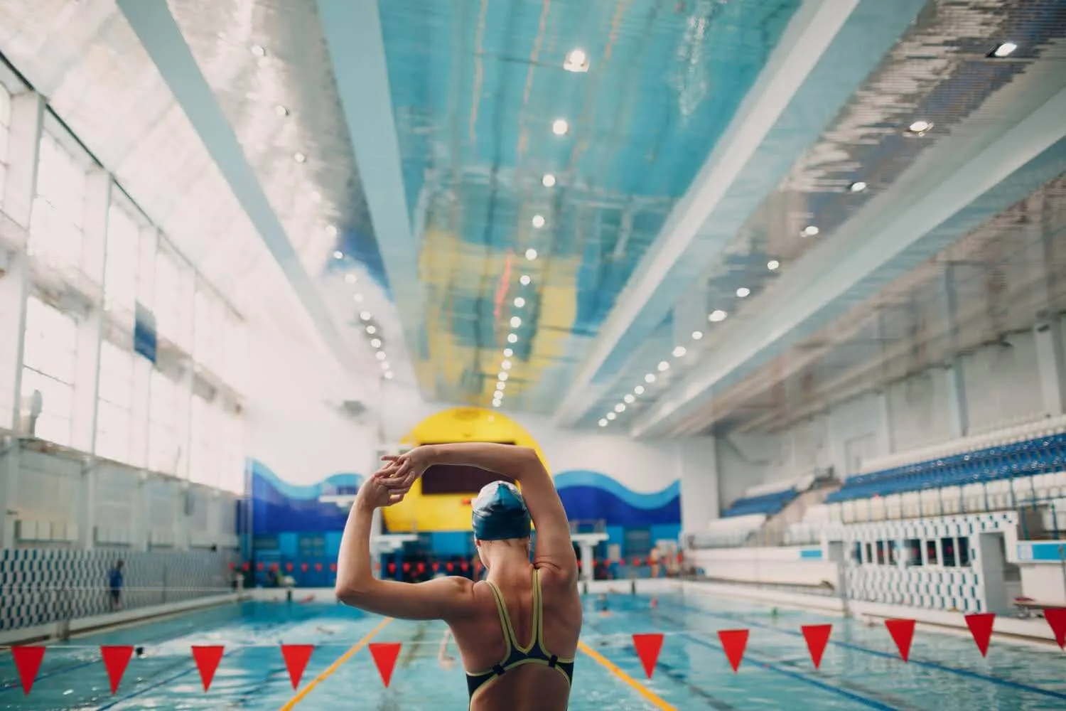 Swimmer putting on a swim cap in an indoor pool