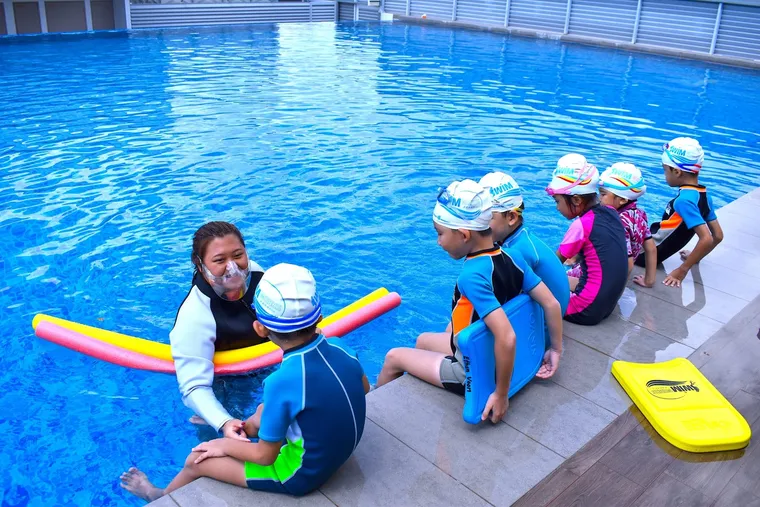 SwimSafe coach with a group of kids at the poolside