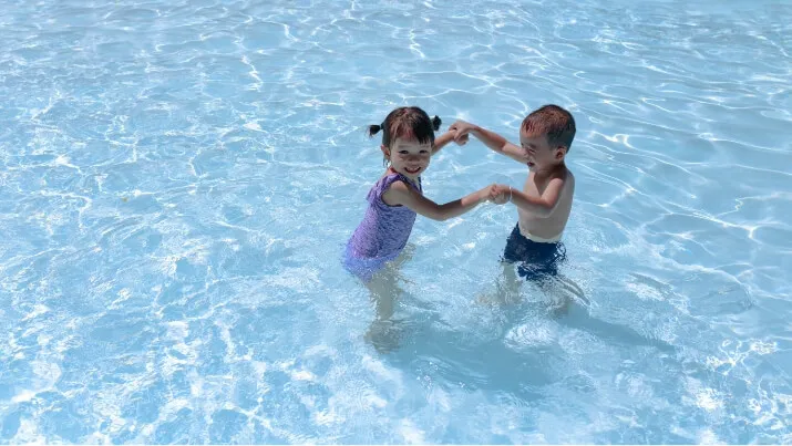 Two toddlers playing in a pool