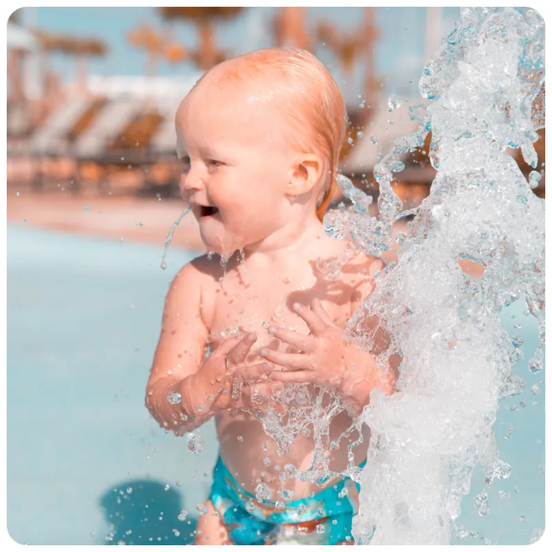 Toddler splashing water in a pool