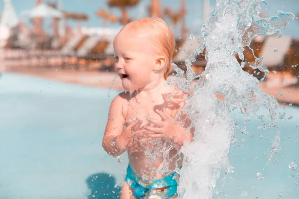 Toddler splashing water in a pool