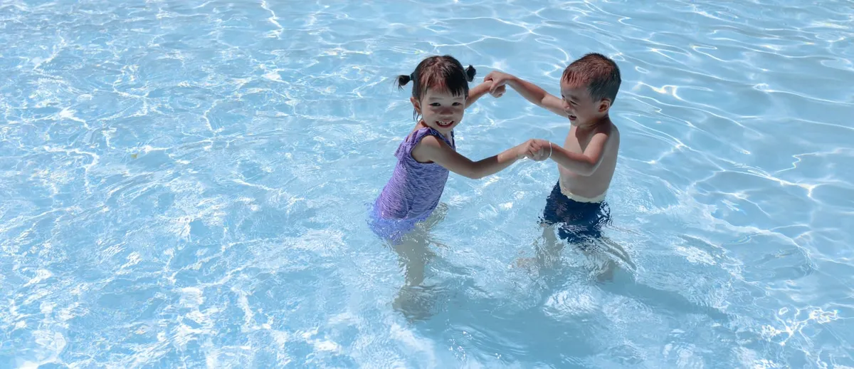 Two toddlers playing in a pool