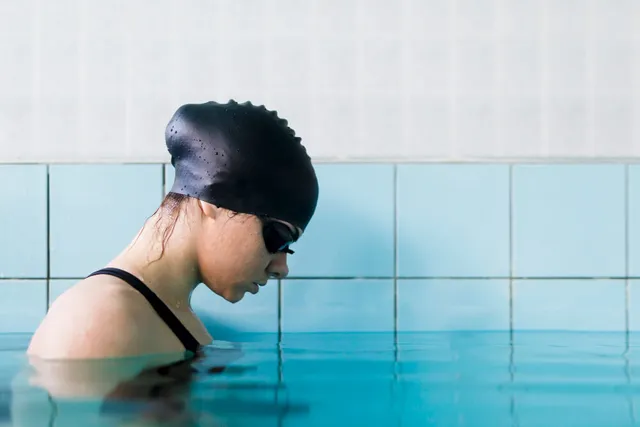 Woman swimmer in a cap and goggles