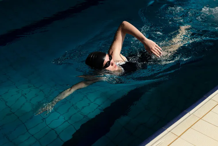 Woman swimming freestyle in a pool
